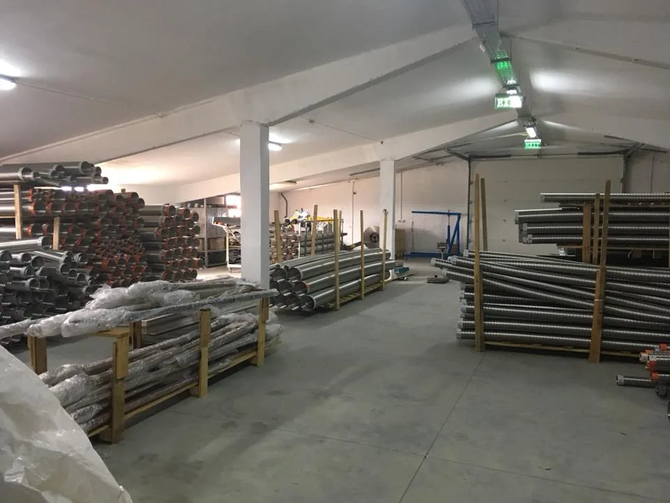 Tuburi și profile metalice stivuite într-o hală de depozitare